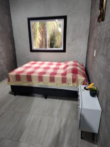 łóżko w pokoju z oknem i stołem w obiekcie Casa Rustica w mieście Baía da Traição