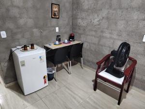 een kamer met een tafel, een stoel en een koelkast bij Casa Rustica in Baía da Traição