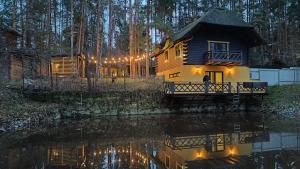 a house with a reflection in the water at night at Ekodom in Voropayev