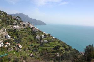 uma aldeia numa colina junto à água em Amalfi Montemare Rooms em Amalfi