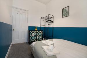 een slaapkamer met een bed met handdoeken erop bij 3 Bed-Free Parking-Close to City in Low Team