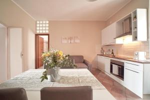 a kitchen and living room with a table with flowers on it at Casa nostra aeroporto e mare in Fiumicino