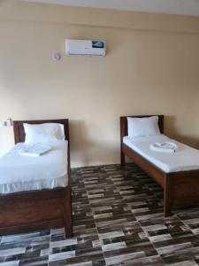 2 Betten nebeneinander in einem Zimmer in der Unterkunft Two Palms in Jambiani