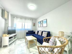 sala de estar con sofá azul y TV en LaFrenchTouch - Amplio apto con piscina y parking, en Torremolinos
