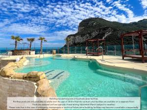 a swimming pool with a slide in the water at Luxury 1 Bed - City Suites Ocean Spa Plaza in Gibraltar