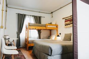 a bedroom with a bunk bed and a chair at Apart hotel de Hostal Concepción in Concepción