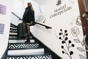 a woman walking down an escalator with a suitcase at Apart hotel de Hostal Concepción in Concepción