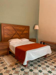 um quarto com uma cama e uma cabeceira em madeira em Casa La Cuarta em San Luis Potosí