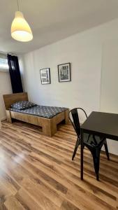 - une chambre avec un lit, une table et une chaise dans l'établissement Warszawa Centrum Pokoje, à Varsovie