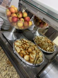a buffet with pies and apples and other food at HOTEL TRES LAGOAS in Três Lagoas