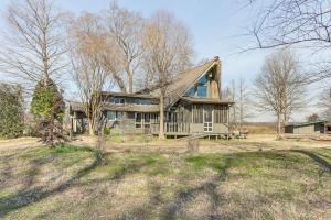 an old house with a gambrel roof on a field at Boat Dock on Reelfoot Lake Tiptonville Retreat in Tiptonville