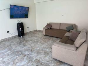 uma sala de estar com um sofá e uma televisão de ecrã plano em Hermosa casa cerca a Cieneguilla em Huarochirí