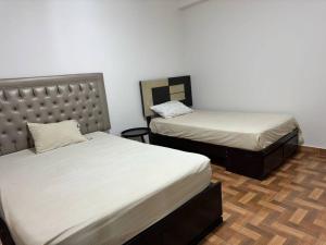 um quarto com 2 camas e uma cabeceira em Hermosa casa cerca a Cieneguilla em Huarochirí