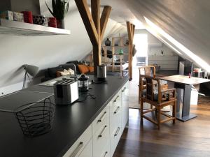 une cuisine avec un comptoir noir et une table dans l'établissement Apartment See-Sicht, à Öhningen
