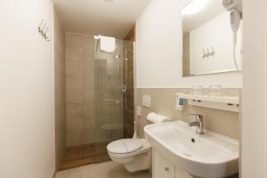 a bathroom with a toilet and a sink and a shower at Safari Hotel in Szeged