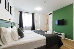 1 dormitorio con 1 cama grande y pared verde en Safari Hotel en Szeged