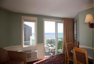 a room with a large window with a view of the ocean at The Corsair & Cross Rip Oceanfront in Dennis Port
