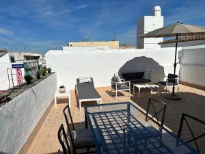 a patio with tables and chairs and an umbrella on a roof at ESTUDIO CON TERRAZA CHILL in El Puerto de Santa María