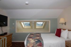 a hotel room with a bed and a window at The Corsair & Cross Rip Oceanfront in Dennis Port