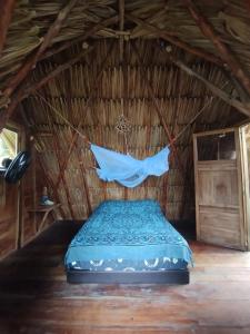 Ce lit se trouve dans une chambre au toit de chaume dotée d'une moustiquaire. dans l'établissement SakaNibue, à San Bernardo del Viento