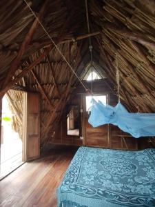 1 dormitorio con 1 cama en una habitación con techo de paja en SakaNibue en San Bernardo del Viento