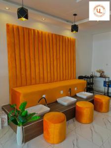Apartment PARIS في ياوندي: غرفة انتظار مع مقعد برتقال وكراسي برتقال