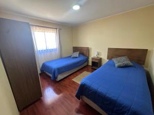 a bedroom with two beds and a window at Alojamiento de casa Angol in Angol