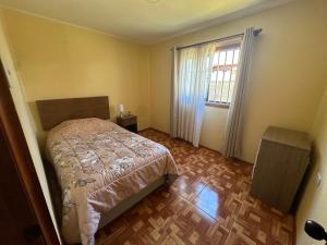 a small bedroom with a bed and a window at Alojamiento de casa Angol in Angol