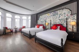 a hotel room with two beds and a wall mural at Indochine Boutique Hotel Ninh Bình in Ninh Binh