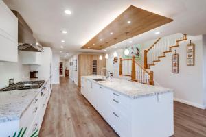 a kitchen with white cabinets and a sink and a staircase at Point Loma Serenity in San Diego