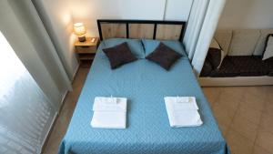 a blue bed with two towels on top of it at ILIRIA Apartment in Durrës