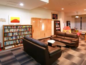 biblioteca con sofás, mesa y estanterías en Shoji Mount Hotel - Vacation STAY 83000v en Narusawa