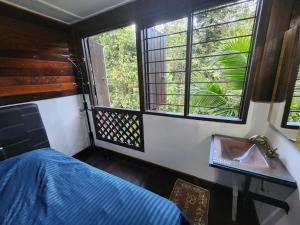 a bedroom with a bed and a window and a sink at Rock Forest Chalet in Bentong
