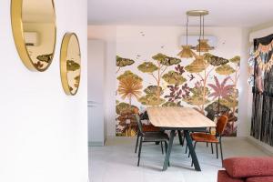 a dining room with a table and a wall mural at L'orée de la Forêt in Desvres