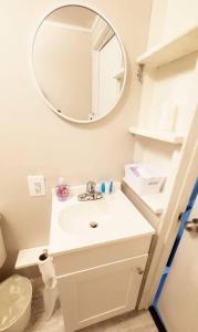 een witte badkamer met een wastafel en een spiegel bij Irmo Cottage Oasis-Cozy Efficiency Apt in Irmo