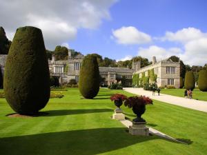 um jardim com árvores e um edifício ao fundo em 2 Bed in Fowey LTBUZ em Cardinham