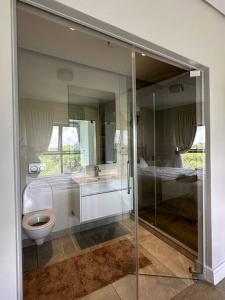 a bathroom with a glass shower and a toilet at House of Grace with Backup power Next to OR Tambo in Kempton Park
