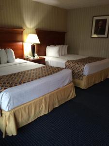 a hotel room with two beds and a lamp at Hotel Pentagon in Arlington