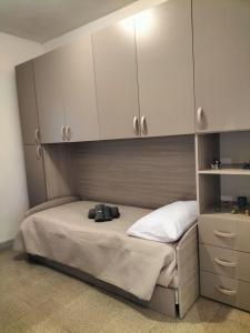 a bedroom with a bed with white cabinets and shoes on it at Villa CasArte in Bari