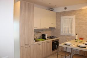 a kitchen with white cabinets and a table with chairs at Villa CasArte in Bari