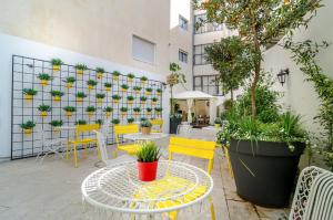 een patio met een tafel, stoelen en planten bij Dizengoff square boutique in Tel Aviv