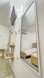 a mirror in a room with a bed and a tv at Hotel Balcon de Oro Curumani in Curumaní