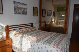 1 dormitorio con cama y espejo en Apartamento Edificio Vistamar - Playa de Barro, en Barro de Llanes