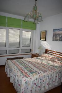 een slaapkamer met een bed met een quilt bij Apartamento Edificio Vistamar - Playa de Barro in Barro de Llanes