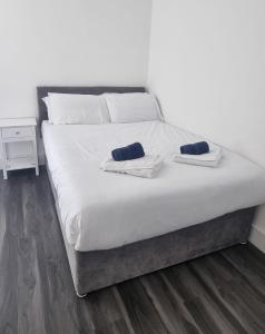 ein großes weißes Bett mit zwei Kissen darauf in der Unterkunft Star London Finchley Lane 3-Bed Residence with Garden in Hendon