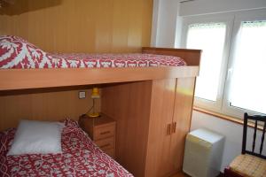 מיטה או מיטות קומותיים בחדר ב-Apartamento Edificio Vistamar - Playa de Barro