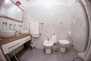 Un baño con lavabo, inodoro y espejo. en White Loft Salerno, en Salerno