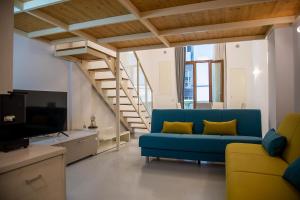Una sala de estar con un sofá azul y una escalera. en White Loft Salerno, en Salerno