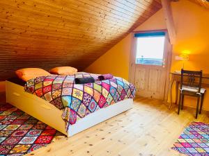 a bedroom with a bed with a colorful quilt at Ferien auf dem Birkenhof in Herisau