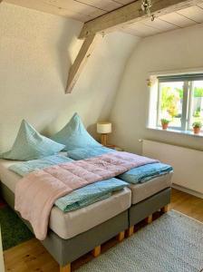 a bedroom with a bed with blue pillows and a window at Remise 2 in Neustadt in Holstein